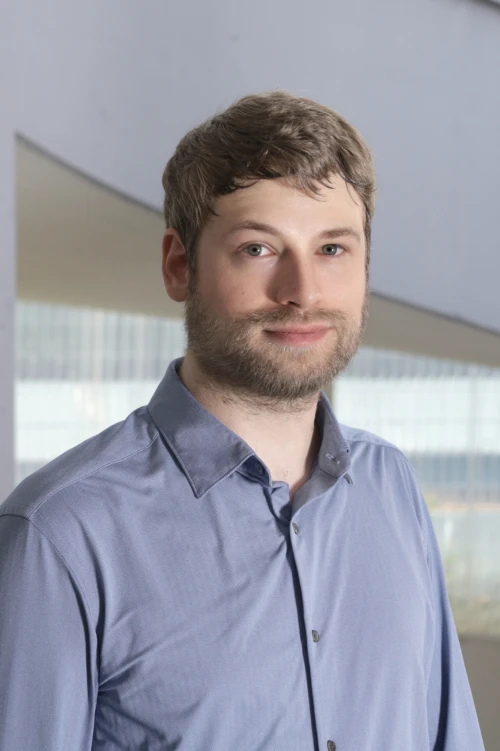 Portraitfoto von Christopher Claas, Mitarbeiter bei der TOPOS Versicherungskontor GmbH, vor einem neutralen Hintergrund.