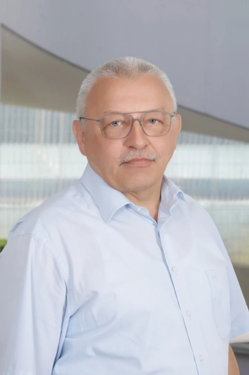 Portraitfoto von Hans-Jörg Ozimek, Mitarbeiter bei der TOPOS Versicherungskontor GmbH, vor einem neutralen Hintergrund.